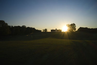 Scenic view of field against clear sky during sunset