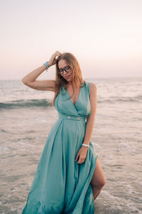 Portrait of young woman standing at beach