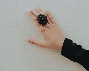 Human hands with a ring against a wall