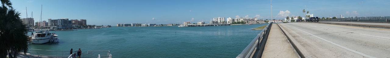 Panoramic view of city by sea against sky