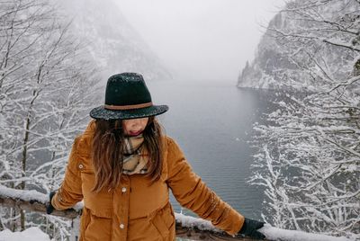 Woman standing against sea during winter