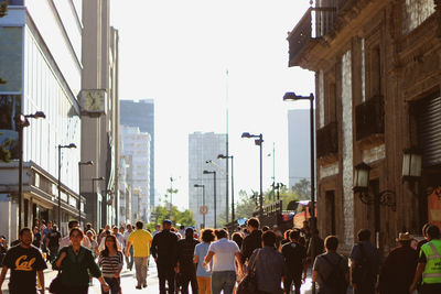 People walking on city street amidst buildings