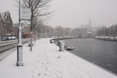 View of frozen river in city during winter