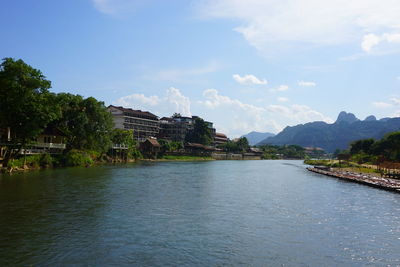 Scenic view of lake by buildings against sky