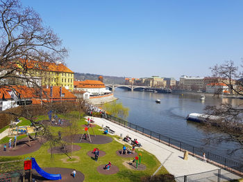 High angle view of people by river against buildings in city