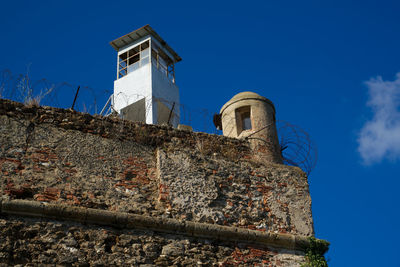 Low angle view of bell tower against blue sky