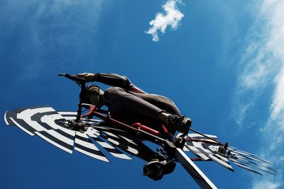 Low angle view of man against blue sky