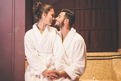 Young smiling couple romancing in bathroom