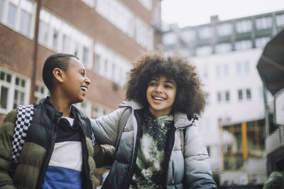 Friends in warm clothing enjoying at school campus