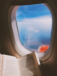 Close-up of book by airplane window