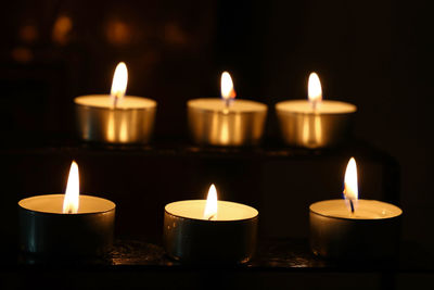 Close-up of lit tea lights in church