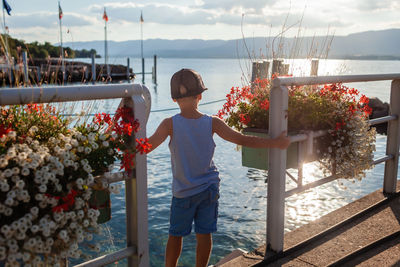 Full length of young man standing by railing