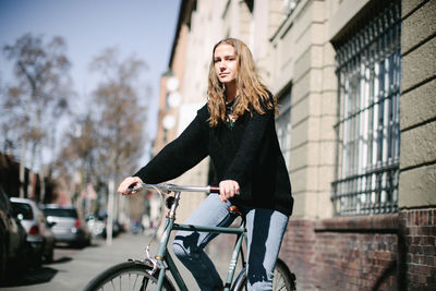Portrait of young woman riding bicycle in city