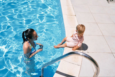 High angle view of siblings in swimming pool