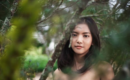 Portrait of young woman amidst branches