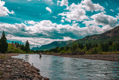 Scenic view of lake by mountains against sky