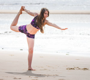 Full length portrait of young woman standing on beach