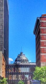 Low angle view of buildings against clear blue sky