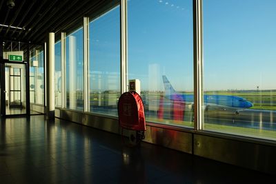 Rear view of man standing by window at airport