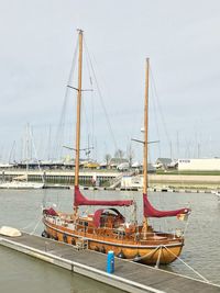 Sailboats moored at harbor