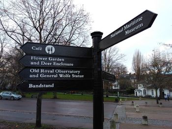 Information sign on road against sky