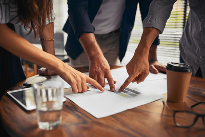 Midsection of business people working on table