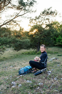 Woman having a break while hiking at sunset. 