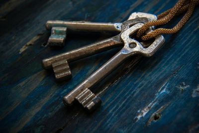 High angle view of old rusty keys on wooden table