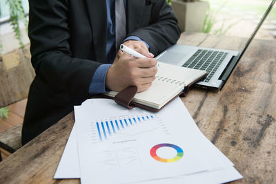 Man using mobile phone while sitting on table