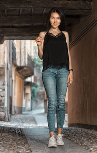 Portrait of woman standing against wall