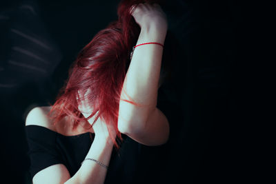 Depressed woman against black background