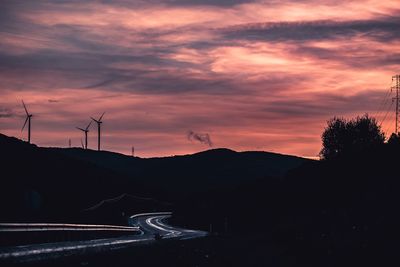 Scenic view of silhouette mountains against orange sky