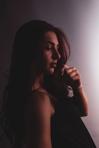 Young woman looking away against white background