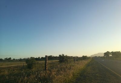 Scenic view of field against clear sky during sunset