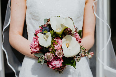 Midsection of woman holding rose bouquet