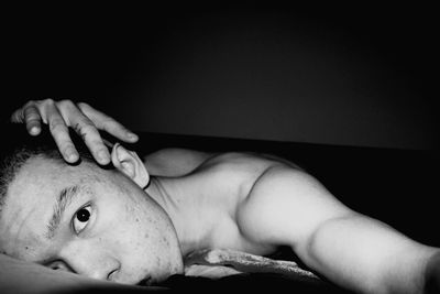Close-up portrait of boy lying on bed