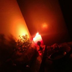 Lit candle in dark room