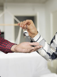 Real estate agent giving house key to customer