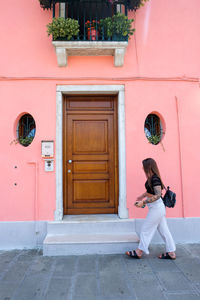 Side view of woman walking by building