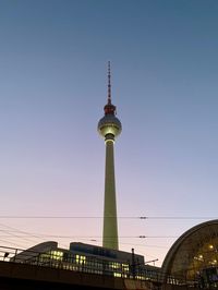 Low angle view of communications tower against sky in city