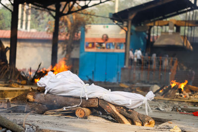 Rear view of man relaxing on wood against building