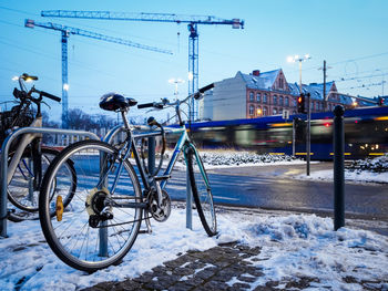 Old bicycle parked on a rack in a winter city, urban environment with construction site 
