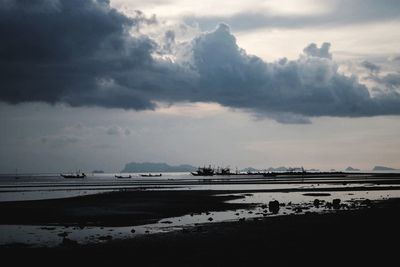 Scenic view of beach against sky at dusk
