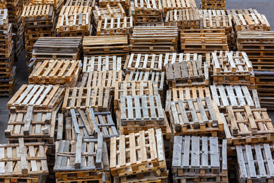 Full frame background of used wooden pallet stacks - perspective view from above