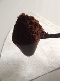 Ground coffee in spoon over table