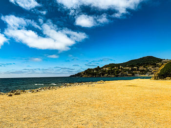 Scenic view of beach against blue sky