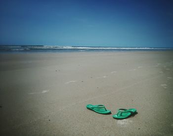 Scenic view of beach against blue sky