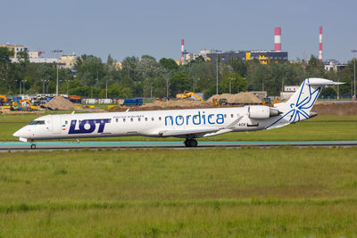 Airplane on airport runway against sky