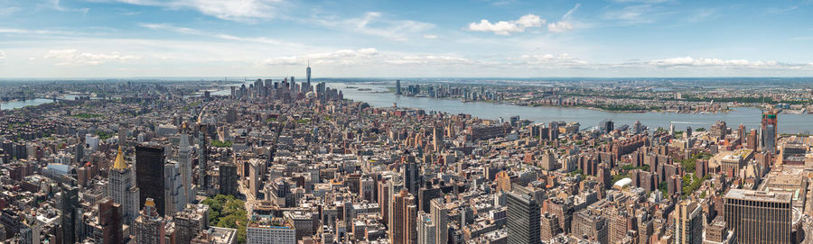 High angle view of modern buildings against cloudy sky