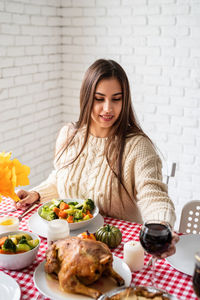 Portrait of smiling woman having food at home